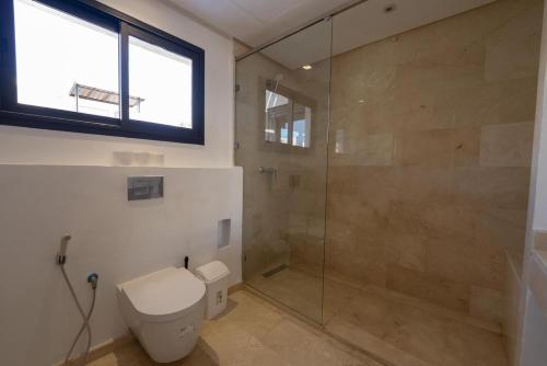 a bathroom with a toilet and a glass shower at Jack Beach Bay in Tamaris