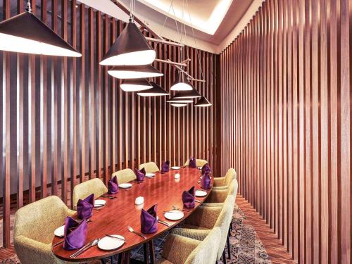 a conference room with a long wooden table and chairs at Mercure Kuala Lumpur Shaw Parade in Kuala Lumpur