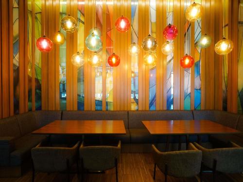 two tables and chairs in a restaurant with lights at Mercure Kuala Lumpur Shaw Parade in Kuala Lumpur