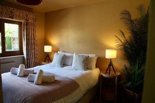 a bedroom with a large white bed with two lamps at A Peaceful Cotswolds Retreat in Bourton on the Water