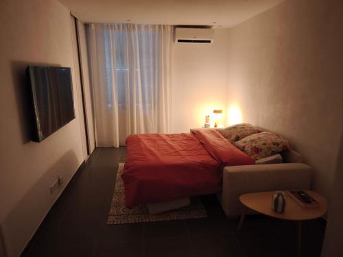 a small bedroom with a bed and a table at Joli T1 bis - Centre ville in Bastia