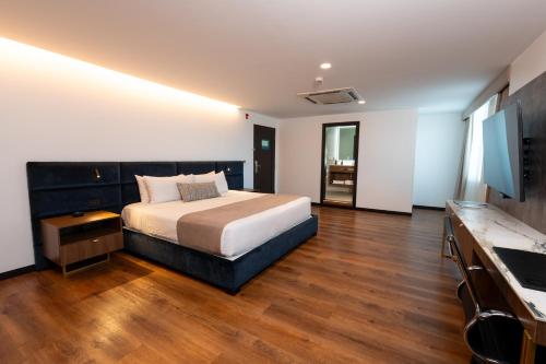 a bedroom with a bed and a wooden floor at Wyndham Quito Airport in Tababela