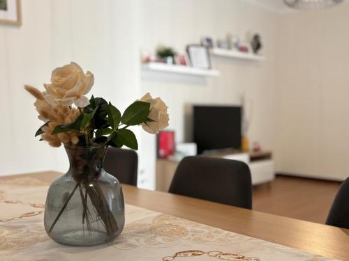 un vaso di vetro con delle rose su un tavolo di B Apartamentos Castelo a Viana do Castelo