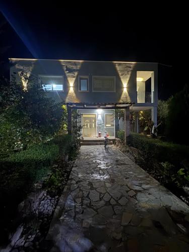 a house at night with a stone walkway in front at Marina Oasis Apartments in Vlorë