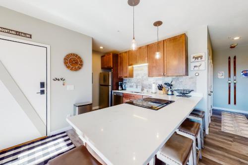 a kitchen with a white counter top and wooden cabinets at Take the Mountain View in Silverthorne