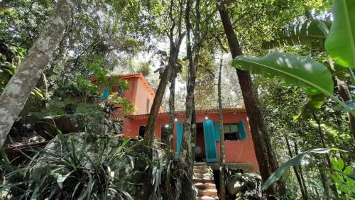 a house in the middle of a forest at Ayur nidhi Eco Hostel in Petrópolis