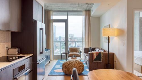 a kitchen with a table and a living room at Natiivo by AvantStay in Austin