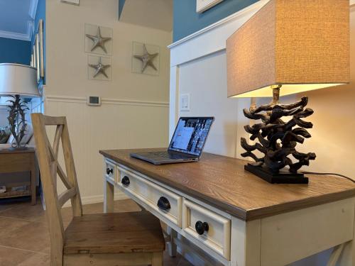 a laptop on a table with a lamp on it at Sunny First-Floor Condo in Bonita National with Golf & Social Membership Ideal 30-Night Stay in Bonita Springs