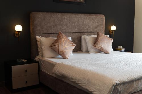 a bedroom with a large bed with pillows at Gold Crest Grand Executive Hotel Apartments DHA Lahore in Lahore