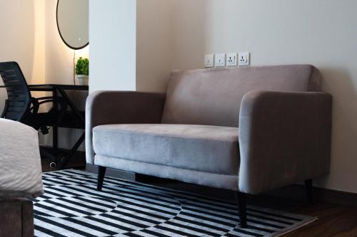 a living room with a couch and a chair at Gold Crest Grand Executive Hotel Apartments DHA Lahore in Lahore
