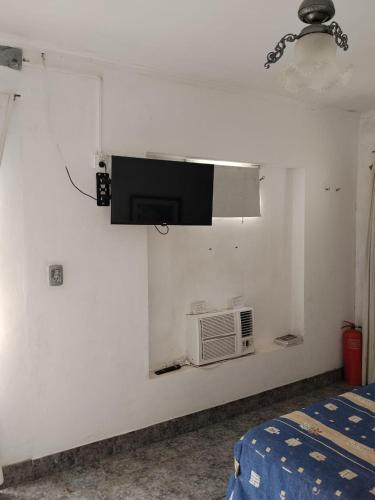 Una habitación con un televisor en una pared con un microondas. en De la Costa, en Victoria