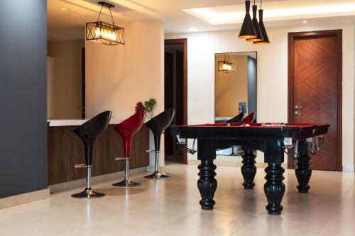 a room with a ping pong table and chairs at Gold Crest Grand Executive Hotel Apartments DHA Lahore in Lahore