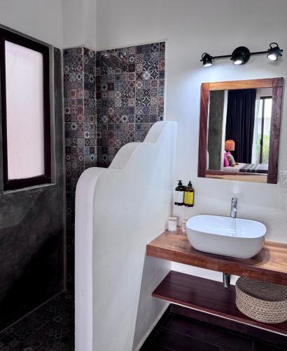 a bathroom with a sink and a mirror at Casa Beu in Puerto Escondido