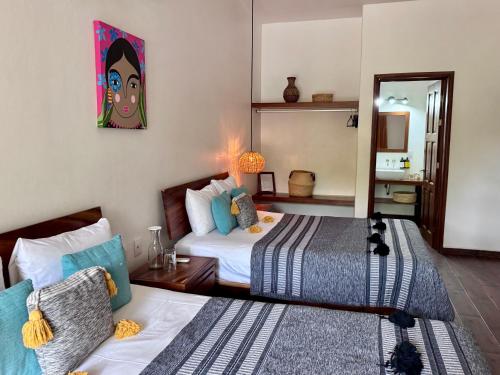 a bedroom with two beds and a mirror at Casa Beu in Puerto Escondido