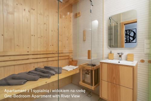 a bathroom with a shower with a sink and a mirror at Jesionowe Apartamenty Ashwood Apartments Widok na Odrę 1,4 km od Rynku Parking Podziemny w Cenie Klimatyzacja Sauna w 1 Apt River Oder view 1,4 km Market Square Underground parking Balcony Air conditioning in Wrocław