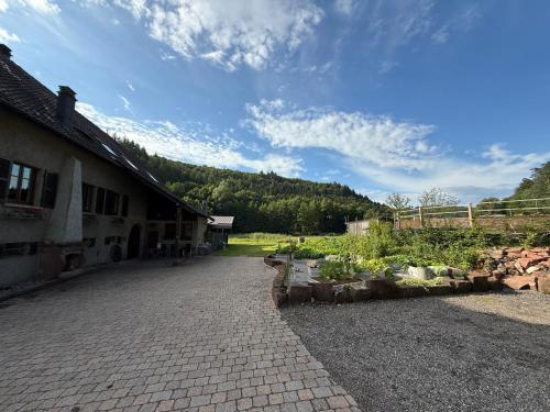 un edificio con un vialetto in mattoni accanto a un giardino di Maison d'hôtes en pleine nature avec chevaux a Soucht