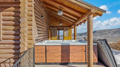 une maison en bois avec un jacuzzi sur une terrasse dans l'établissement Ski and Ride Mountain Haus - Hot Tub, Fire Pit, Game Room & Deck, à Mesa