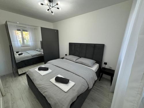 リヴノにあるAmare Apartmentの大きなベッドと鏡のある寝室