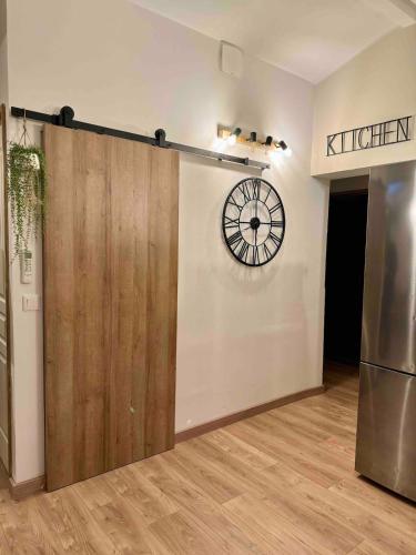 a sliding door in a room with a clock on the wall at Spacieux & cozy, wifi gratuit, parking, proximité plage 15 min in Puget-sur Argens