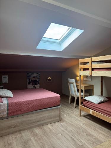 a bedroom with a bed and bunk beds with a skylight at Spacieux & cozy, wifi gratuit, parking, proximité plage 15 min in Puget-sur Argens