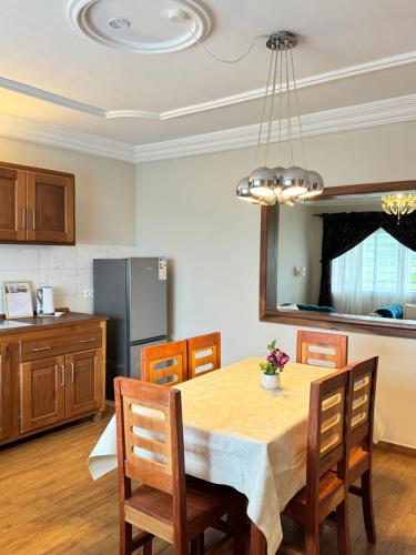 a kitchen and dining room with a table and chairs at Akhard Haus in Buea