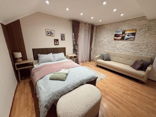 a bedroom with a large bed and a couch at Cozy Family House in Lazarevac