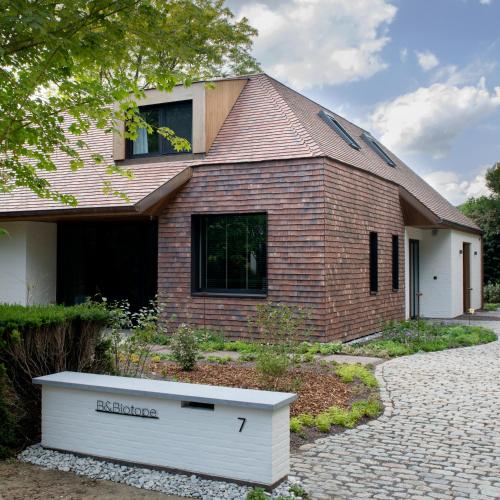 a brick house with a large white box in front of it at B&Biotope in Heusden