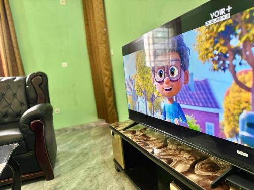 Una televisión o centro de entretenimiento en Charming apartment in Yaoundé - Nkolmesseng