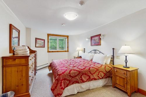 a bedroom with a bed with a red comforter at Latitude Adjustment in Jay