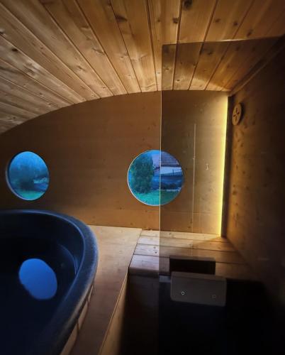 a bathroom with a blue tub and two windows at Hotel Baia Rosie Resort in Slănic