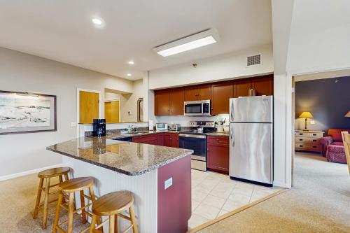 a kitchen with a refrigerator and some bar stools at Kestrels Unit #16 in Morses Mill
