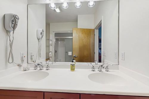a bathroom with two sinks and a large mirror at Kestrels Unit #16 in Morses Mill