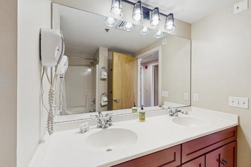 a bathroom with two sinks and a large mirror at Kestrels Unit #16 in Morses Mill