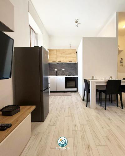 a kitchen with a table and a black refrigerator at Luminis Holiday Home in Porto Torres