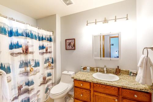 a bathroom with a toilet and a sink with a shower curtain at Talisman Sweet Retreat in Nutria