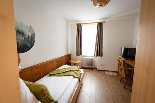 a small bedroom with a bed and a television at Wald Villa Schönau in Schönau an der Brend