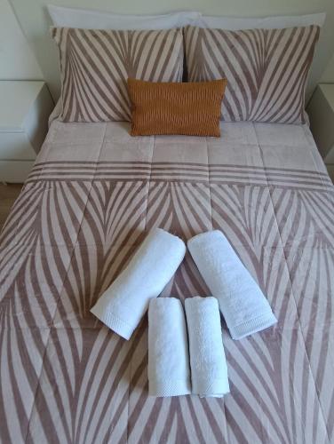 a bed with two white towels on top of it at Apartamentos Gabín in Montederramo