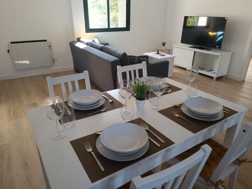 Una mesa de comedor con platos y copas de vino encima. en Apartamentos Gabín, en Montederramo