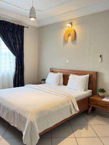 a bedroom with a large bed and a window at Akhard Haus in Buea