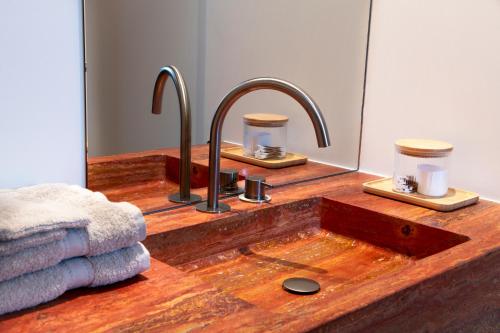 a bathroom with a wooden sink with two faucets at B&Biotope in Heusden