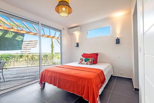 a bedroom with a bed and a large window at Appartement Canne Noire in Richemont
