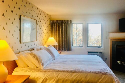 a bedroom with a large bed and two windows at Trailside Highlands #7 in Morses Mill