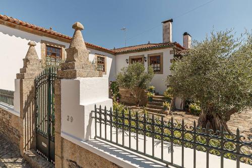 a white house with a black fence at Casa dos Araújos in Mirandela