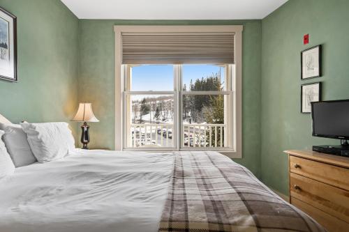 a bedroom with a large bed and a window at Long Trail House 368 in Stratton Mountain