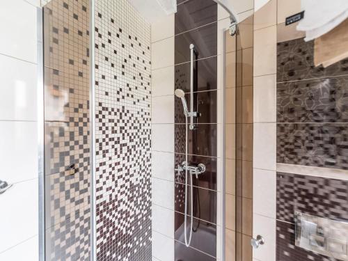 a shower with a glass door in a bathroom at Comfortable holiday homes close to the beach in Grzybowo