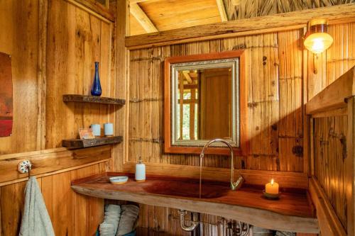 a bathroom with a sink in a wooden cabin at Finca Aveterra, Luxurious Riverside Retreat in Mindo