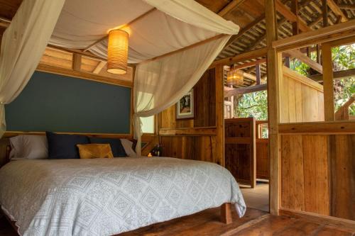 a bedroom with a bed in a wooden room at Finca Aveterra, Luxurious Riverside Retreat in Mindo