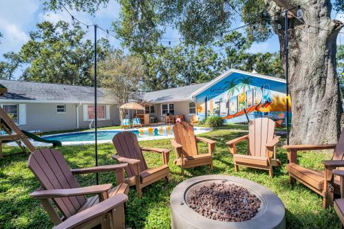 une cour arrière avec des chaises, un arbre et une piscine dans l'établissement 5BR Family Pool Villa By Eagle Park, à Clearwater