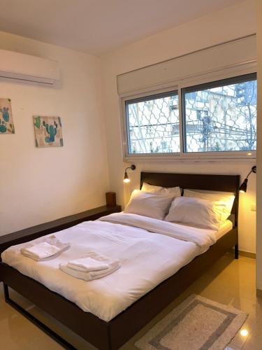 a bedroom with a large bed with two towels on it at Cozy apartment near the beach in Haifa