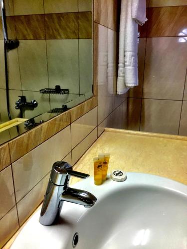 a bathroom sink with a faucet and a mirror at Irene Villa in Ierápetra